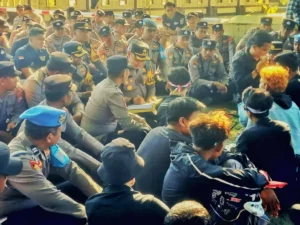 Kapolres Sumenep AKBP Rivanda (tengah) menandatangani kertas berisi materi tuntutan massa yang berdemonstrasi di mapolres setempat, Sabtu (30/08). (Foto KM-05)