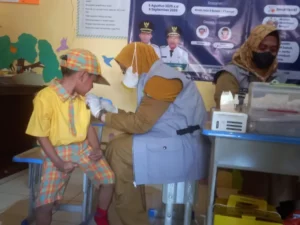 Seorang anak diimunisasi campak dalam program imunisasi massal yang digagas Pemkab Sumenep, Senin (25/8). (Ist)