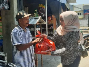 Anggota Fraksi PDI Perjuangan DPRD Jawa Timur, Indri Yulia Mariska menyerahkan paket sembako dari MH Said Abdullah kepada abang becak di Kecamatan Kota, Sumenep, Selasa (23/09).