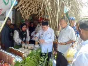 Wakil Bupati Sumenep Imam Hasyim (berkopiah) mencicipi produk olahan di salah satu bazar peserta Festival Tani Nasional 2025 di Kecamatan Kota, Rabu (24/09). (Foto KM-05)