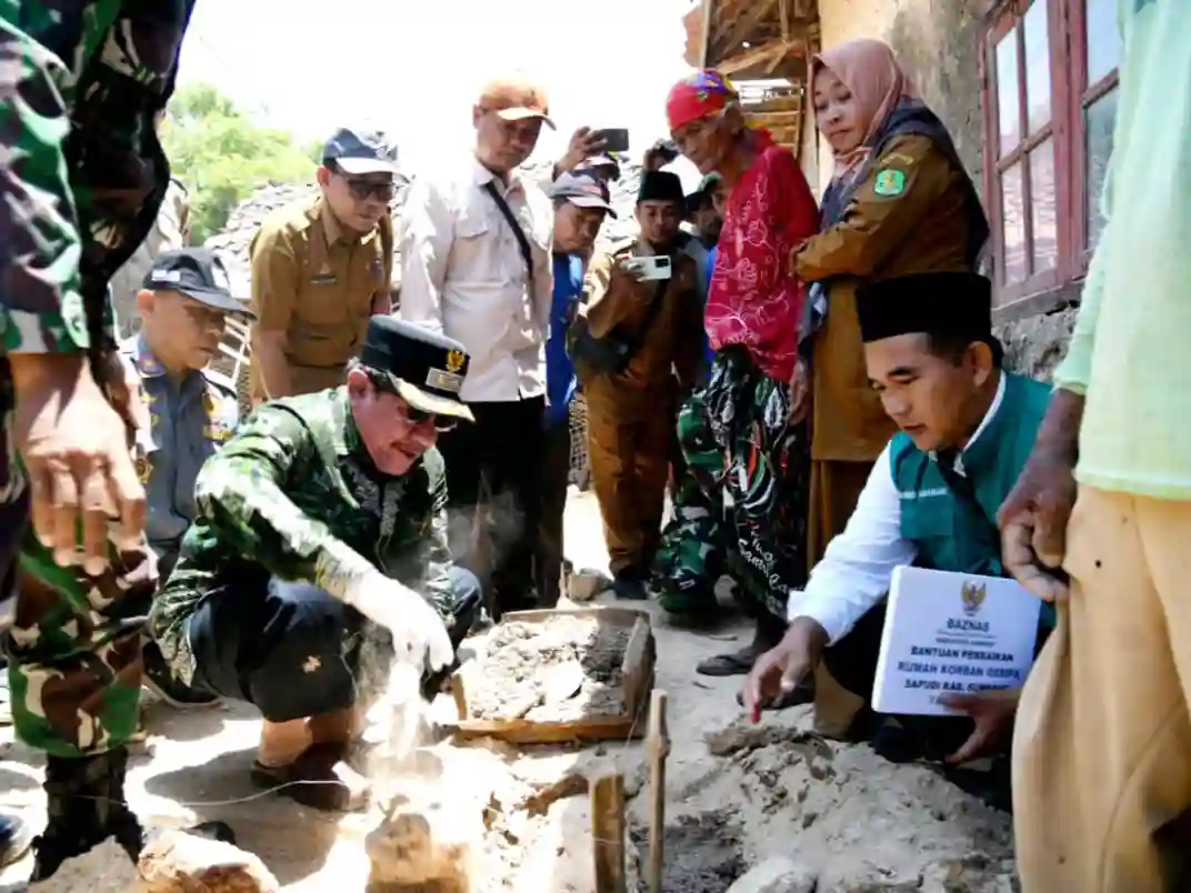Wakil Bupati Sumenep Imam Hasyim (batik hijau) memasang batu pertama perbaikan rumah yang rusak sangat berat di Pulau Sapudi, Senin (6/10). (Ist)