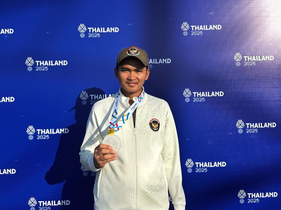 Bagas Syarief Hidayat menunjukkan medali perak yang diraihnya di cabor petanque nomor "triple man" di Sea Games 2025, Thailand, Senin (15/12). (Ist)