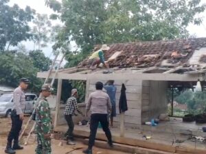 Personel Polsek dan Koramil Guluk-Guluk bersama warga setempat membersihkan sisa-sisa kerusakan bangunan yang diterjang angin puting beliung, Senin (22/12). (Ist)