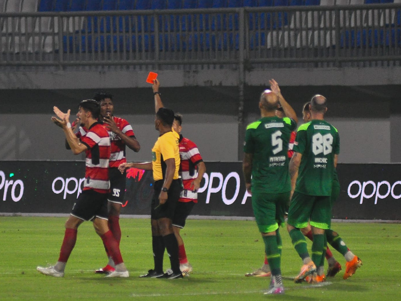 Wasit Eko Saputro mengeluarkan kartu merah bagi pemain belakang Madura United, Mendonca, dalam laga lawan Persebaya di Stadion Gelora Madura Ratu Pamelingan, Pamekasan, Sabtu (3/1) malam. (Foto: KM 06)